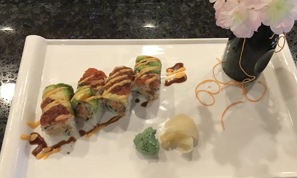 Spicy tuna avocado sushi rolls drizzled with dual sauces, served with pickled ginger and green wasabi paste at Sakura Japanese Restaurant, a Japanese restaurant in Wilmington