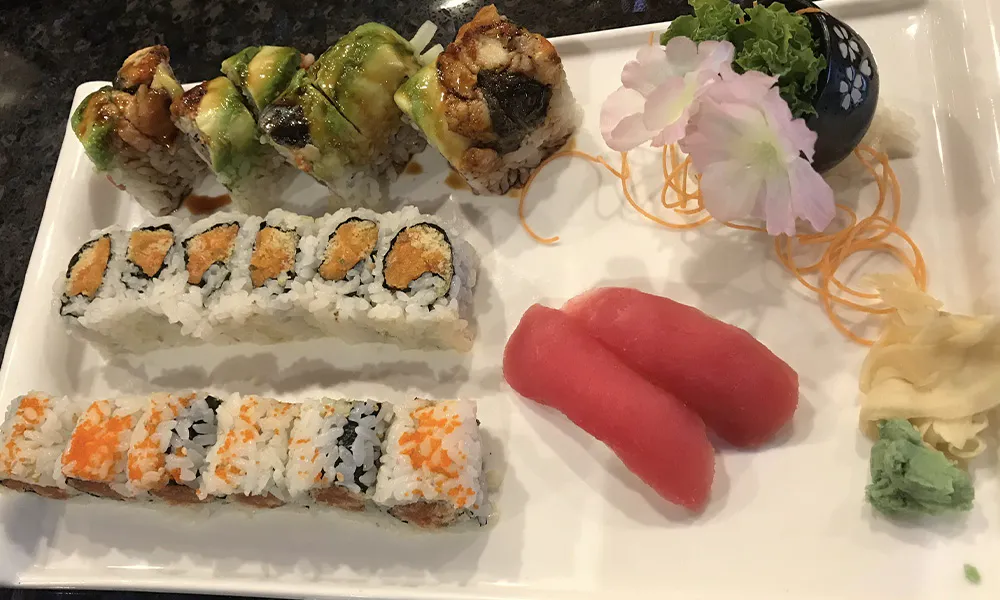Variety sushi platter with unagi rolls, crunchy maki and two tuna nigiri slices plus floral vegetable garnish at Sakura Japanese Restaurant, a Japanese restaurant in Wilmington